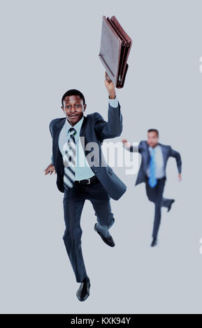 Felice afroamerican uomo correre con una valigetta in mano. in background- il suo collega cercando di catturare fino a lui. Foto Stock