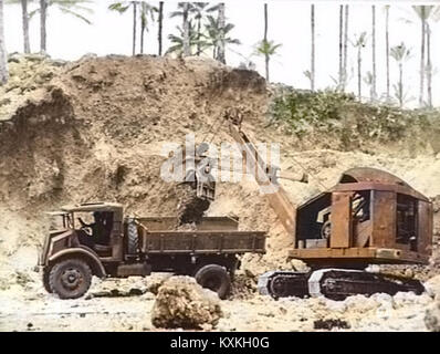 Questa fotografia del 1944 mostra una pala dell'esercito australiano che scarica ghiaia su un camion a Jacquinot Bay, evidenziando la logistica militare durante la seconda guerra mondiale nel teatro del Pacifico. Foto Stock