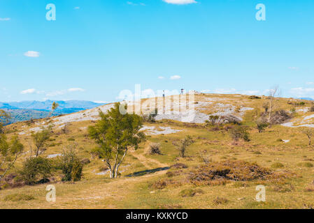 Walkers approccio un cairn sul crinale di Whitbarrow cicatrice nel Parco nazionale del Lake District Cumbria Foto Stock