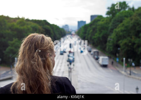 donna che guarda giù per una strada trafficata di berlino Foto Stock