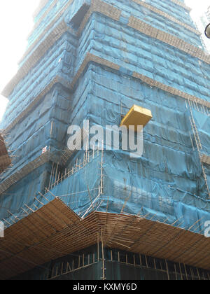 Una fotografia che mostra le tradizionali impalcature di bambù utilizzate nella costruzione di Hong Kong. L'immagine evidenzia l'uso duraturo del bambù come materiale da costruzione, apprezzato per la sua forza, flessibilità e sostenibilità nell'architettura urbana. Foto Stock