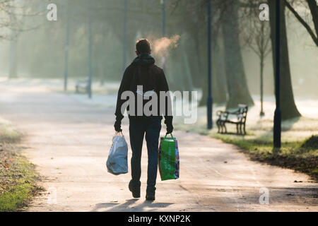 Aberystwyth Wales UK, giovedì 11 Jan 2018 UK Meteo: gente camminare nel parco su una amaramente e gelido freddo mattino in Aberystwyth, con temperature ben al di sotto del congelamento dopo una notte di chiaro cielo privo di nuvole il Met Office ha emesso un avviso di colore giallo per la nebbia, con scarsa visibilità, per gran parte del Galles, il west Midlands e il sud ovest del Regno Unito Photo credit: Keith Morris/Alamy Live News Foto Stock