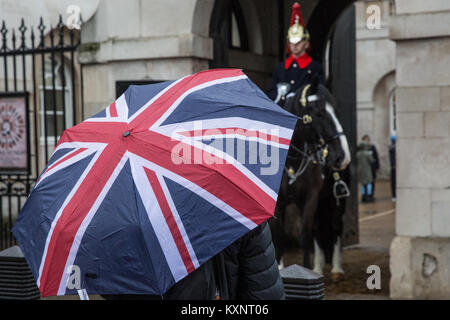 Londra, Regno Unito. Xi gen, 2018. Un turista che porta una Unione Jack ombrello si erge di fronte a montato di guardia di Horseguards Parade. Credito: Mark Kerrison/Alamy Live News Foto Stock