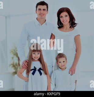 La famiglia felice costituito da mom doughterl papà e figlio guarda la telecamera e sorridente Foto Stock