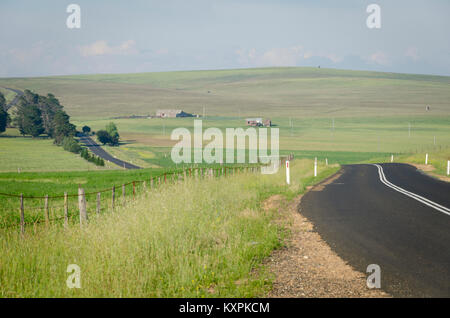 Strada attraverso la campagna, Cooma Aeroporto, Nuovo Galles del Sud, Australia Foto Stock