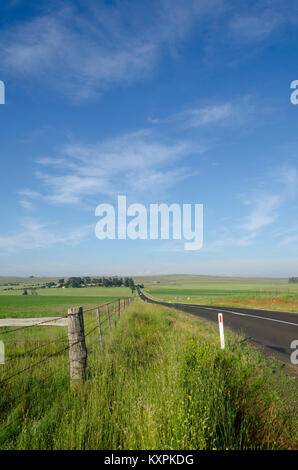 Strada attraverso la campagna, Cooma Aeroporto, Nuovo Galles del Sud, Australia Foto Stock