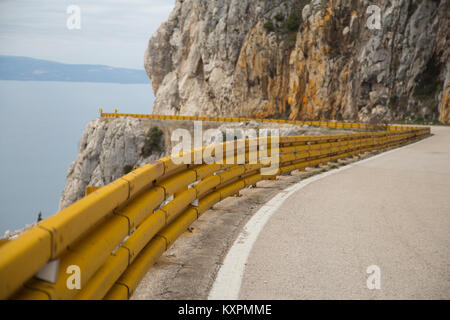 Autostrada Adriatica, percorso europeo E65, con il suo colore giallo barriere di traffico vicino a Podgora in Croazia Foto Stock