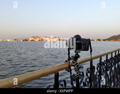 In attesa che il diritto di luce con un riflesso su un treppiede piccolo attaccato ad una ringhiera in Udaipur, Rajasthan, India Foto Stock