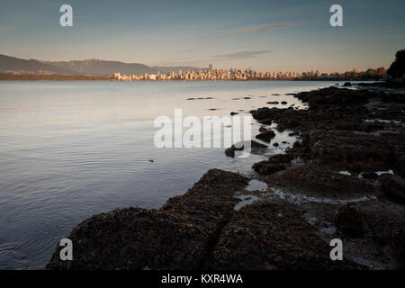 Il centro di Vancouver, BC, è bagnata dal sole di sera, attraverso English Bay da Jericho Beach. Foto Stock