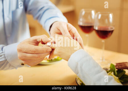 Uomo di mettere l'anello incredibile sul suo dito spose Foto Stock