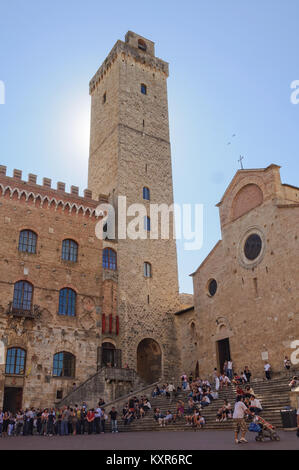 Il sole che tramonta dietro la grande torre (Torre Grossa) - San Gimignano, Toscana, Italia Foto Stock