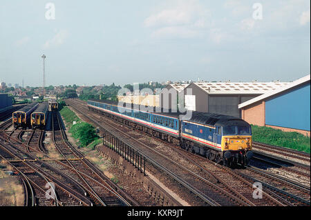 Una classe 47 locomotiva diesel numero 47715 lavora una rete sud-est 'Network Express' service passando l'EMU depot a Wimbledon. Il 17 giugno 1993. Foto Stock