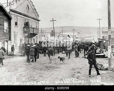 Questa fotografia mostra una folla riunita fuori dall'ufficio postale di Dawson, nello Yukon, nel 1899, che riflette la vita sociale e le infrastrutture nell'era della corsa all'oro di Klondike. Foto Stock