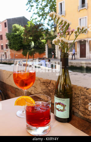 Pomeriggio rilassante cocktail. Aperol spritz e negroni seduti mediante i canali di Venezia durante l'estate. Foto Stock