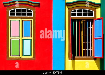 Una coppia di colorati di finestre con persiane di legno su un negozio tradizionale casa nel centro storico di Little India, Singapore Foto Stock