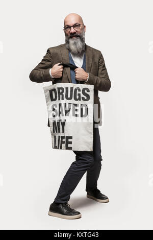L'uomo mostra un sacchetto con slogan, ritratto in studio Foto Stock