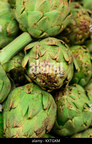 Carciofi freschi in esposizione presso il mercato degli agricoltori per la vendita. Foto Stock