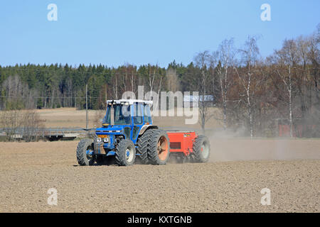 SALO, Finlandia - 14 Maggio 2017: il contadino coltiva con campo blu Ford trattore 6610 e Tume seminatrice in una limpida giornata di primavera nel sud della Finlandia. Foto Stock