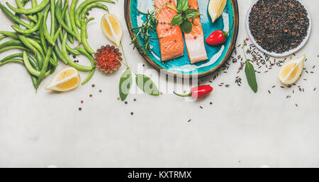 Materie filetti di salmone con verdure, riso e verdi sulla piastra Foto Stock