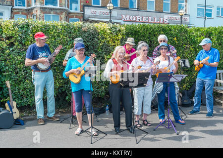 Broadstairs Settimana della Musica Folk Festival. I membri dell'U3A, un gruop che incoraggia le persone anziane di apprendere nuove abilità, giocando sulla passeggiata dalla spiaggia. Foto Stock