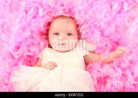 Baby girl rilassante rosa sul letto in piuma Foto Stock
