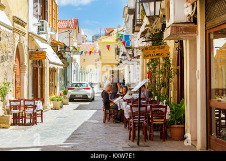 Rethymno, Grecia - 3 Maggio 2016: turisti letti menu a tabelle in street cafe con cucina nazionale. Strada cartello pubblicitario sulla strada turistica. M Foto Stock