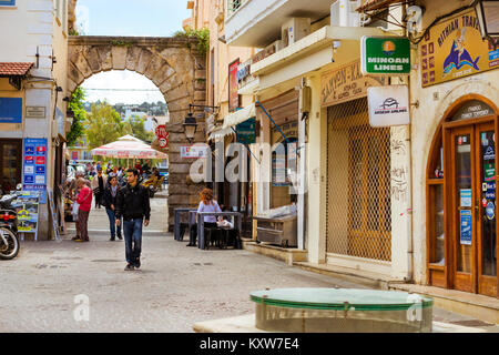 Rethymno, Grecia - 3 Maggio 2016: attrazione turistica Porta Guora. I turisti a camminare per le strade della città vecchia. Strada cartello pubblicitario su touristic Foto Stock