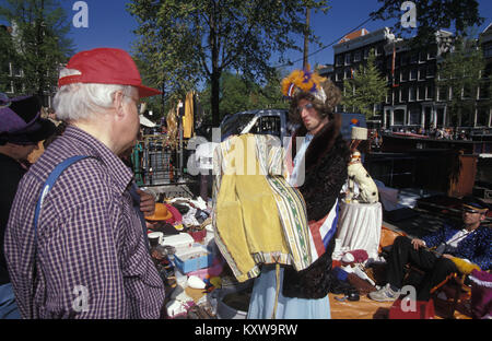 I Paesi Bassi. Amsterdam. Festival annuale il 27 aprile chiamato Koningsdag (Kingsday), per celebrare il compleanno del re. Travestito che vendono vestiti per Foto Stock