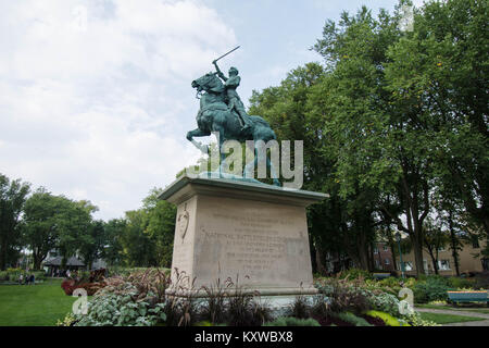 Jeanne of Arche in Quebec su un cavallo con una spada su un zoccolo nella piazza Canada in alto su una piattaforma che sfocia opere d'arte in rame bronzo veloce Foto Stock