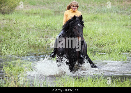 Ritratto di giovane donna bionda di equitazione in campagna Foto Stock