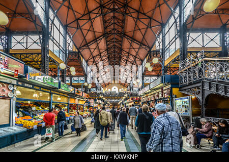 La centrale mercato grande Hall di Budapest Ungheria la vendita di generi alimentari, produrre e negozio di souvenir con la gente del posto e i turisti a piedi sul livello inferiore Foto Stock
