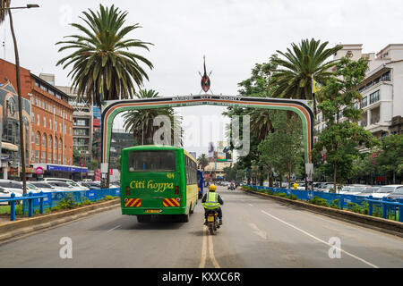 Visualizza in basso Kenyatta Avenue con la città di Nairobi County segno sopra la strada come veicoli auto al di sotto di esso, Nairobi, Kenia Foto Stock