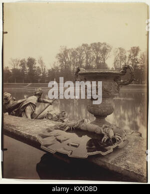 Una fotografia di Eugène Atget che raffigura il bacino di Nettuno alla Reggia di Versailles, in Francia. L'immagine cattura i dettagli scultorei della fontana monumentale e il design simmetrico del paesaggio. Foto Stock