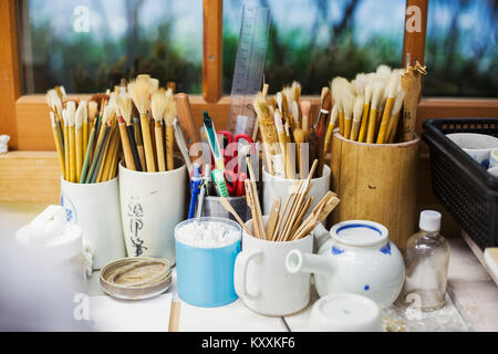 In prossimità di una selezione di pennelli e strumenti in un giapponese workshop di porcellana. Foto Stock