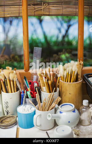 In prossimità di una selezione di pennelli e strumenti in un giapponese workshop di porcellana. Foto Stock