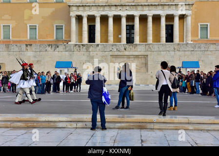 I turisti a guardare il cambio della guardia Evzones cerimonia nella parte anteriore della tomba greca di saldatura sconosciuto dal palazzo del parlamento Foto Stock