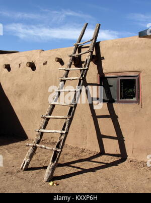 A sudovest scaletta appoggiata contro la parete di adobe in Taos Pueblo, Nuovo Messico Foto Stock