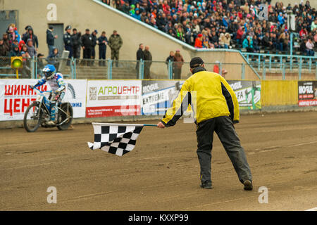 Rivne, Ucraina - 11 Ottobre 2015: l'uomo con una bandiera a scacchi fine mostra a Open Cup Speedway per il giorno della città Rivne Foto Stock