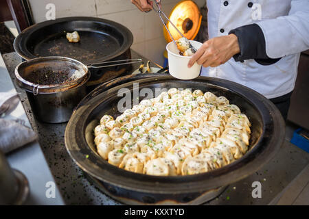 Sheng Jian Bao e Guo tirante essendo confezionato - Shanghai pan gnocco fritto in padella tradizionale Foto Stock