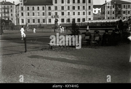 Fotografia che mostra le persone che giocano a tennis sui vecchi campi di San Sebastián, Spagna. L'immagine appartiene all'archivio Car-Kutxa Fototeka e cattura le attività sportive ricreative dell'inizio del XX secolo. Foto Stock