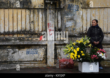 Hanoi, Vietnam - 14 dicembre 2017. Un venditore ambulante che vende i fiori freschi sul bordo della strada nel vecchio centro storico di Hanoi Foto Stock