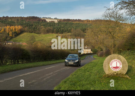 Auto passando contorno marcatura di pietra ingresso North York Moors National Park & Kilburn white horse scolpite sulla collina - North Yorkshire, Inghilterra, Regno Unito. Foto Stock