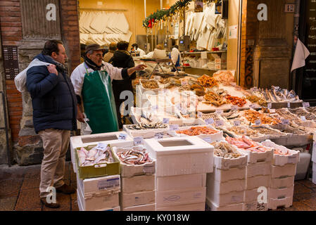 Bologna, Italia - dicembre 2017: le persone e i venditori in Via Pescherie Vecchie, un famoso vicolo pieno di negozi tradizionali e stand gastronomici in characte Foto Stock