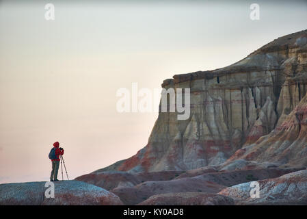 Una persona che spara in colorate canyon mongolo Tsagaan Suvarga. Il paesaggio luminoso di un tessiturali striped canyon Foto Stock