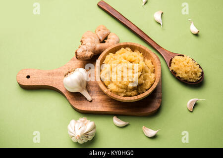 Purea di zenzero fresca / pasta di Adrak in ciotola bianca con tutto crudo su sfondo bianco. Messa a fuoco selettiva Foto Stock