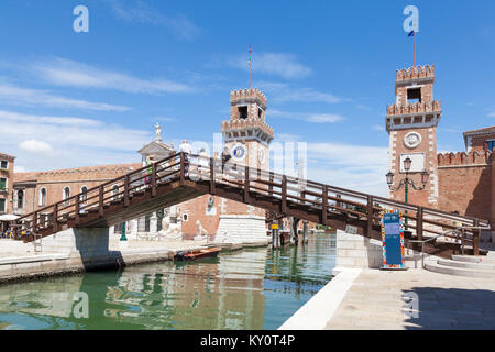 I turisti in piedi sul Ponte del l' Arsenal o del Paradiso ammirando l'ingresso dell'Arsenale di Venezia con riflessioni sul Rio de l'Arsenal Foto Stock