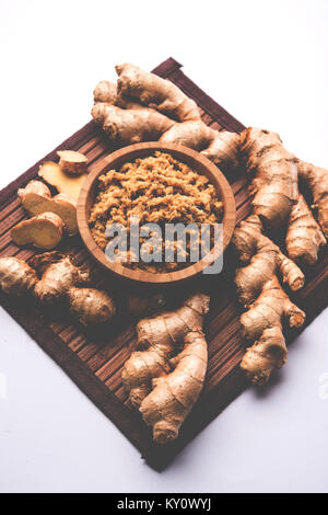 Purea di zenzero fresca / pasta di Adrak in ciotola bianca con tutto crudo su sfondo bianco. Messa a fuoco selettiva Foto Stock