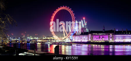 Il London Eye e il fiume Tamigi illuminato di notte. Foto Stock