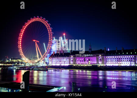 Il London Eye e il fiume Tamigi illuminato di notte. Foto Stock