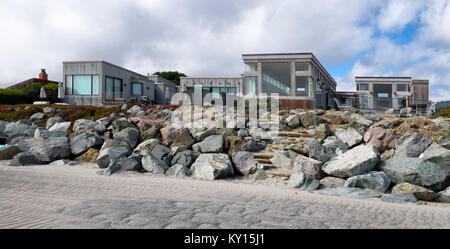 Stinson Beach, California case sul fronte oceano. Massi sovrapposti e la spiaggia di sabbia in primo piano. Architettura moderna dispone di vetro e cemento. Foto Stock